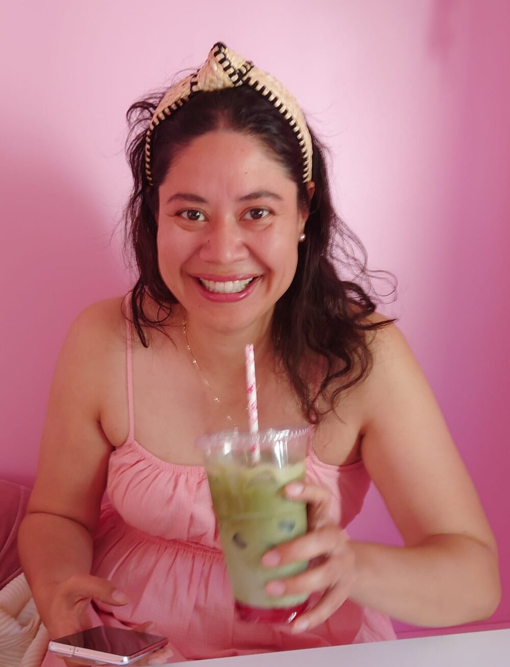 Josy Kang smiling in a pink café